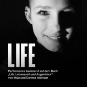 Ein schwarzer Hintergrund. Das Gesicht eines Mädchens ist in Schwarz weiß zu sehen. Ihr Kopf ist rasiert. Der Titel lautet Life. Der Untertitel Performance basierend auf dem Buch „ Life. Lebenszeit und Augenblick“ von Maja und Daniela Aldinger